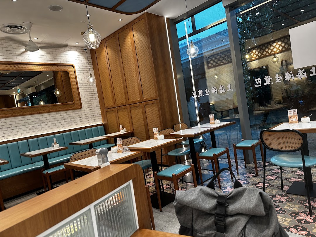 Interior view of a restaurant with tables, chairs, and a large window.