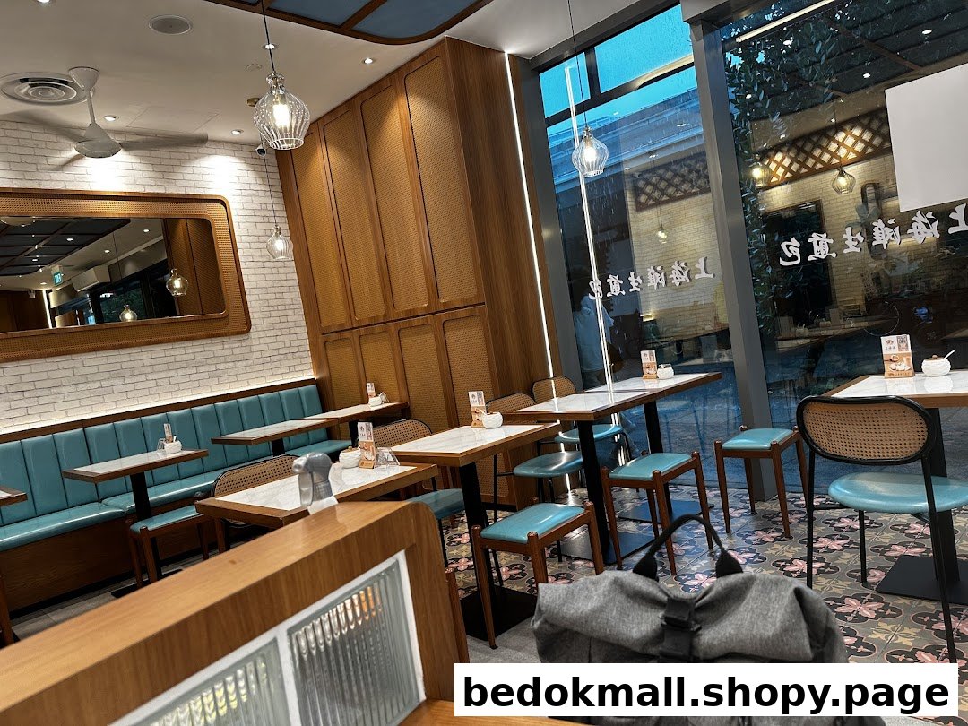 Interior view of a restaurant with tables, chairs, and a large window.