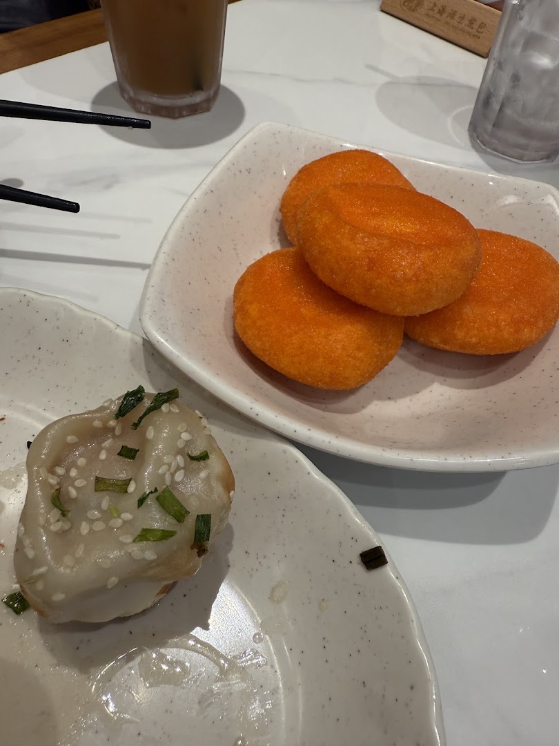 Food items including a dumpling and orange fried snacks on plates.