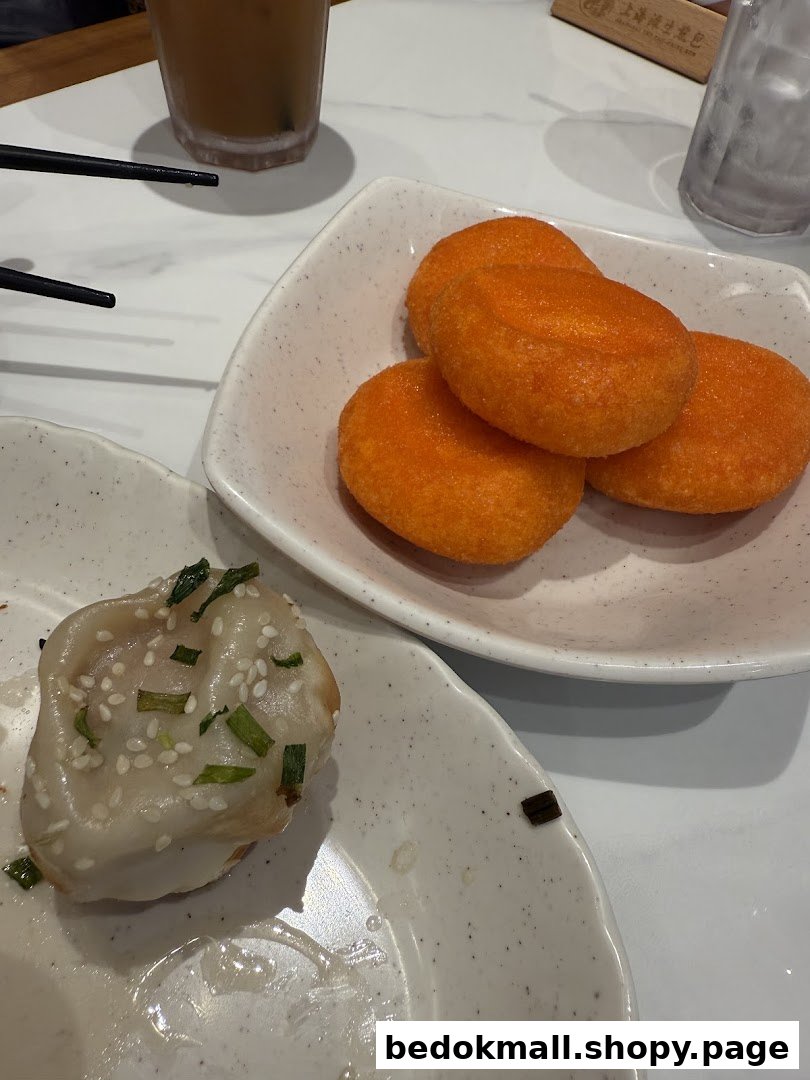 Food items including a dumpling and orange fried snacks on plates.