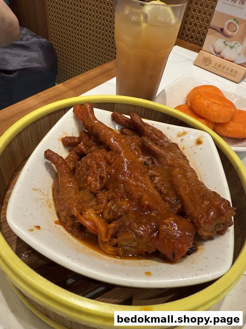 Plate of chicken feet and orange buns with a drink on a table.