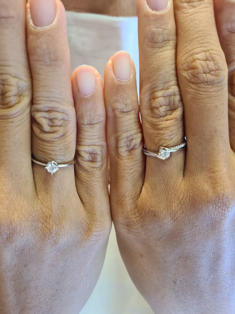 Two hands wearing diamond rings.