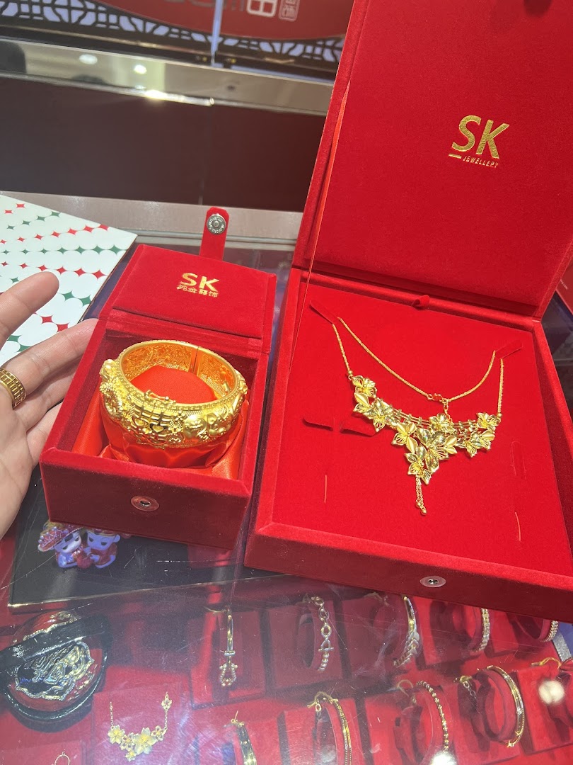 Gold jewelry in red velvet boxes displayed in a shop.