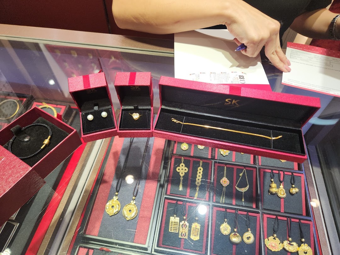 Jewelry display with red boxes and a person's hand filling a form.