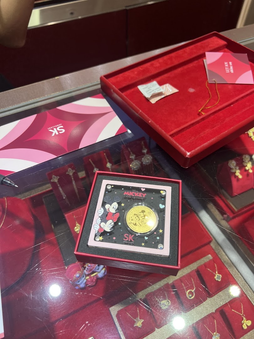 Interior view of a jewellery shop display with a Mickey Mouse gold coin.