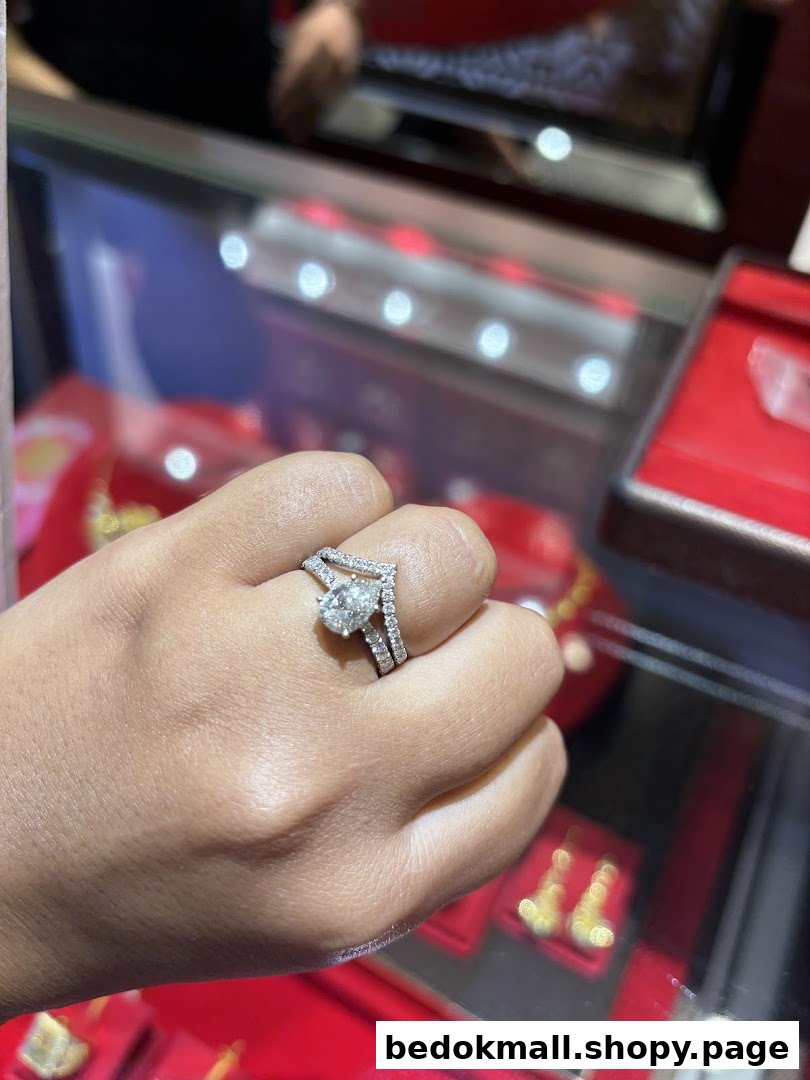 Hand wearing a diamond ring in a jewelry store display case.