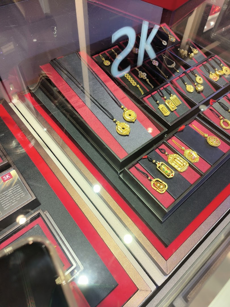 Gold jewelry, including necklaces and pendants, displayed in a glass case.