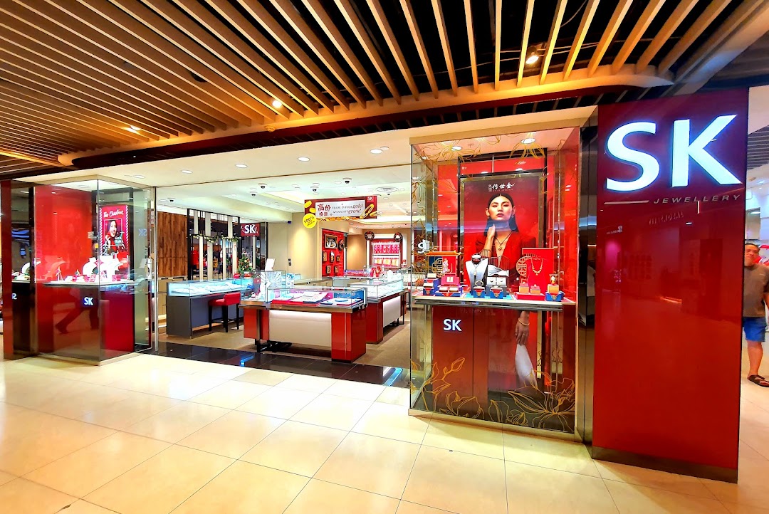 Front view of a jewelry shop with display cases and red accents.