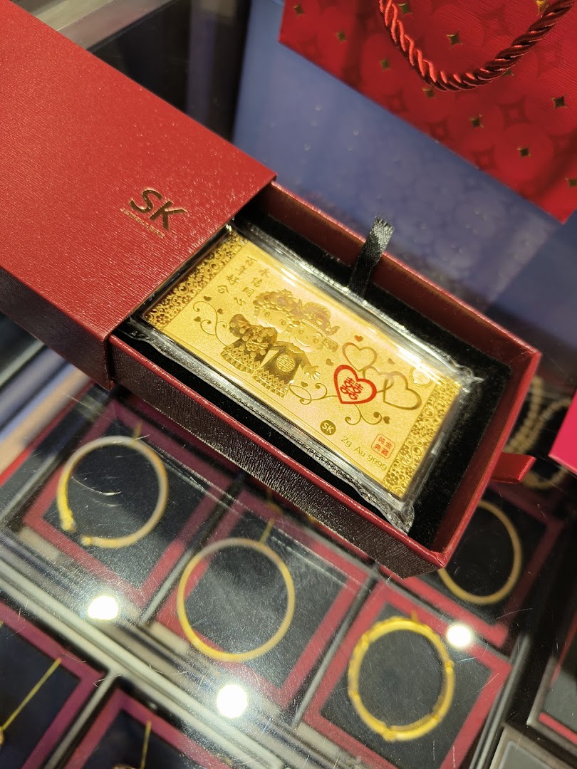 Close-up of a gold bar in a red box on a display case with jewelry.