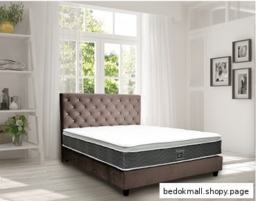 A bed with a mattress and tufted headboard in a room.