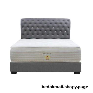 A white mattress on a grey bed frame with a tufted headboard.