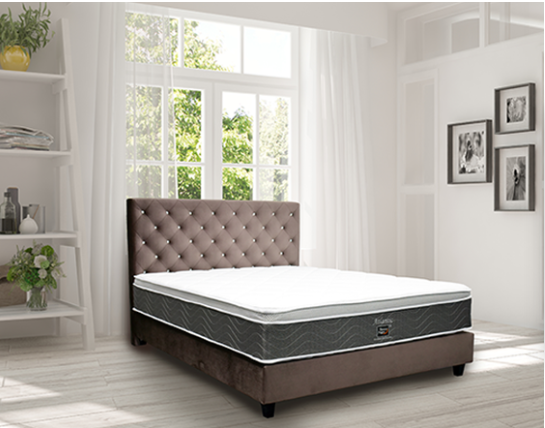 A bed with a mattress and tufted headboard in a bright room.