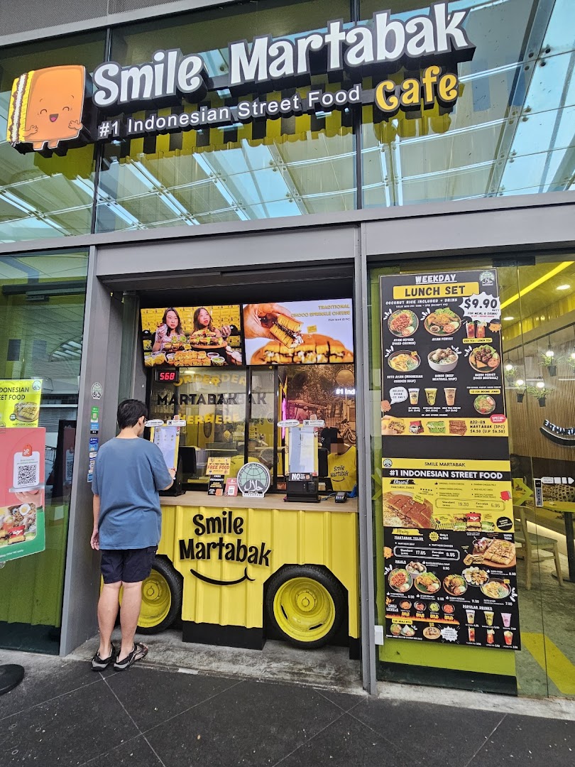 Exterior view of Smile Martabak Café with a customer at the ordering counter.