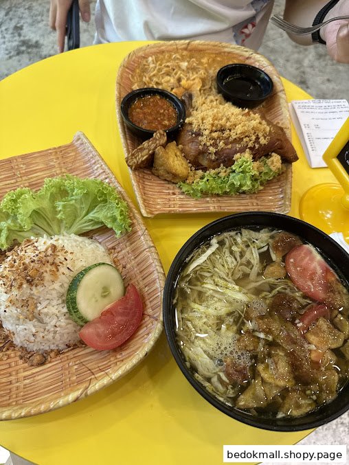 Multiple food dishes, including rice, fried chicken, and soup, on a yellow table.