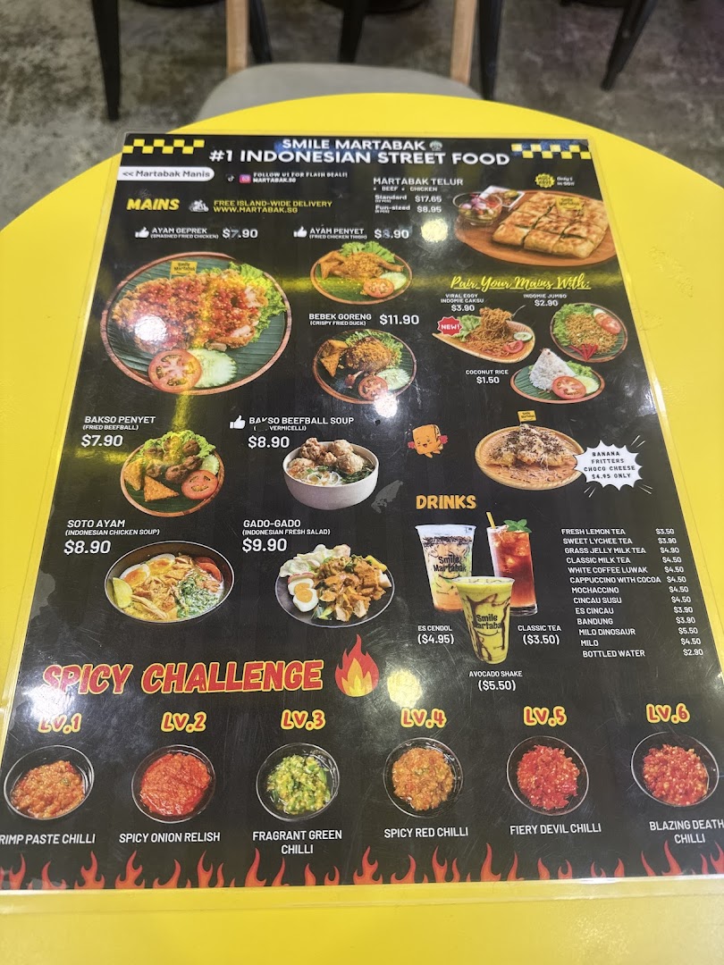 A laminated menu displaying Indonesian street food, drinks, and spicy chili options.