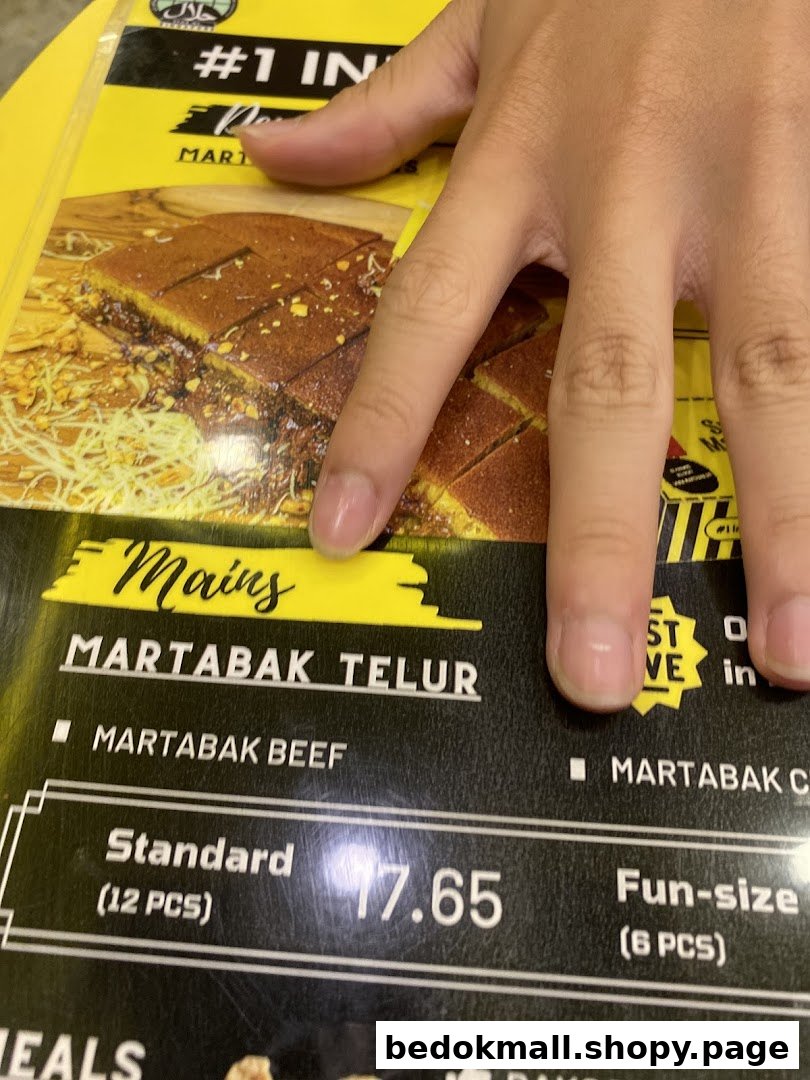 A hand points to a menu displaying Martabak options and prices.