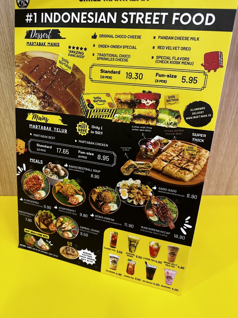 A detailed menu board displaying Indonesian street food and drinks with prices.