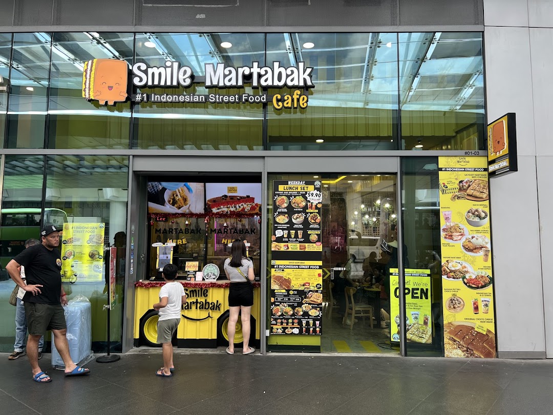 Exterior view of Smile Martabak Café with people outside.