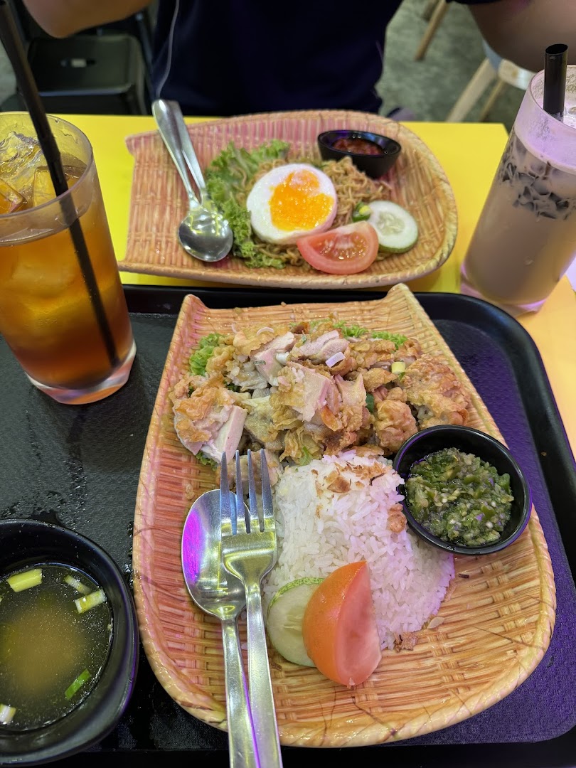 Two plates of food with drinks on a yellow table.