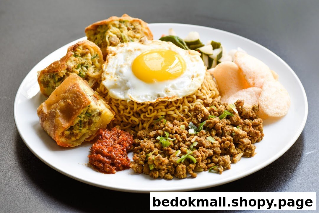 A plate of noodles with fried egg, minced meat, martabak, and crackers.