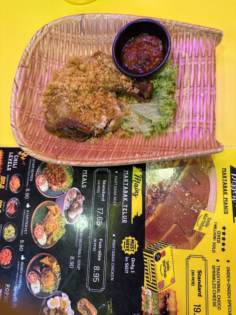Fried chicken dish on a table next to a detailed food menu.