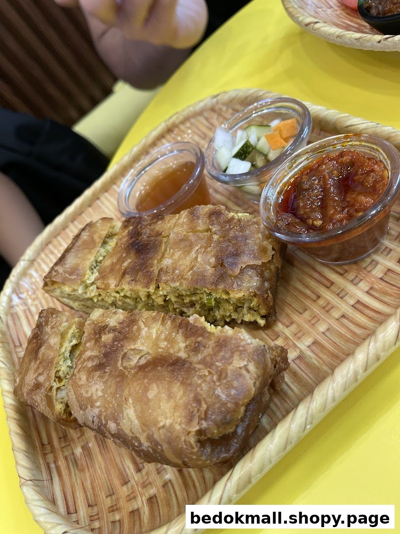 Martabak on a woven tray with three small bowls of sauces.