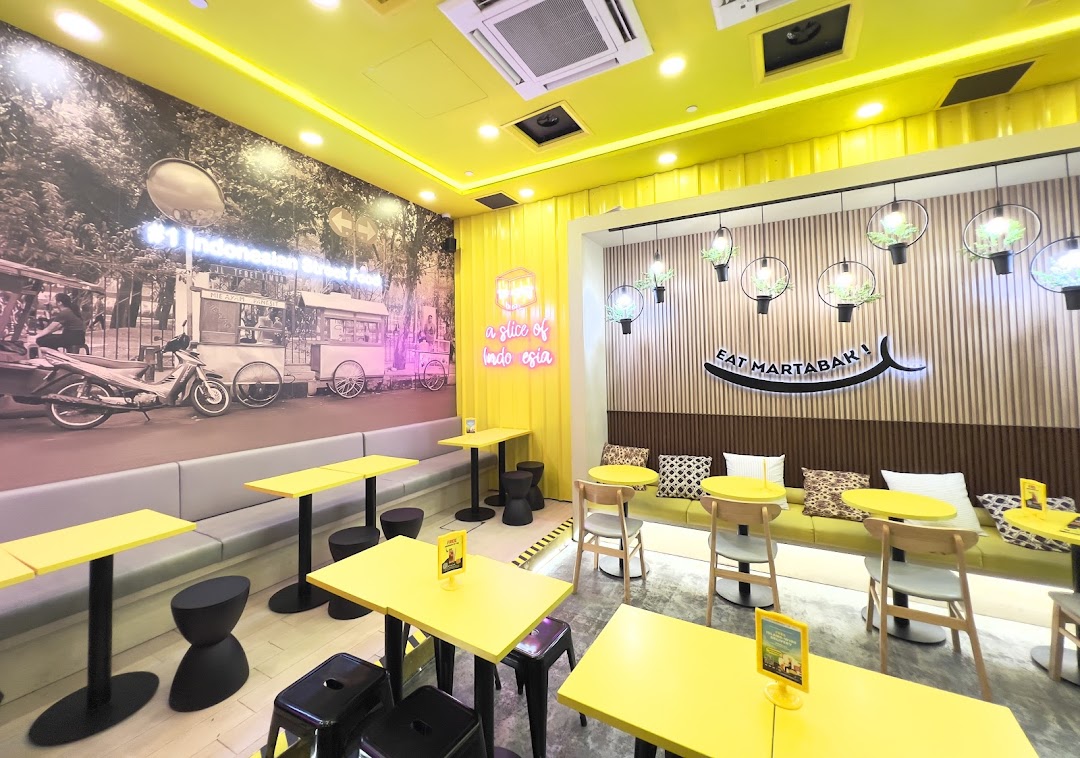 Bright yellow cafe interior with various seating and wall murals.