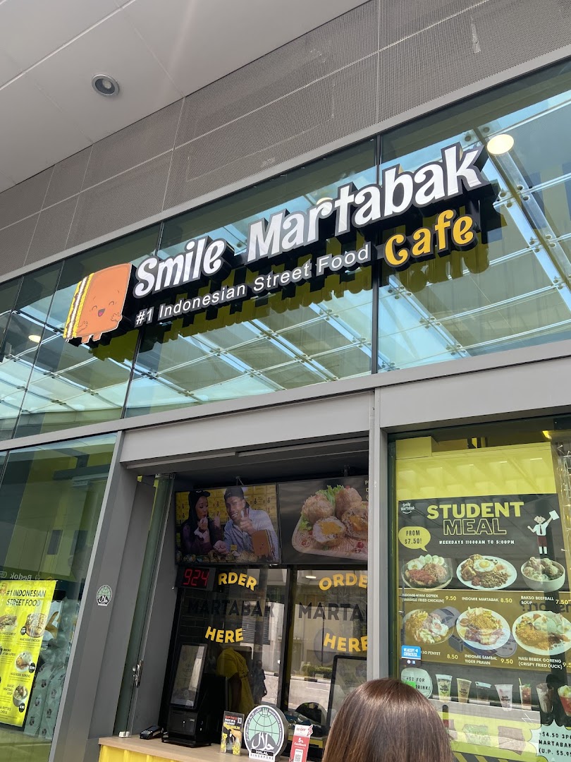 Shop front with large sign, glass windows, and visible menu displays.
