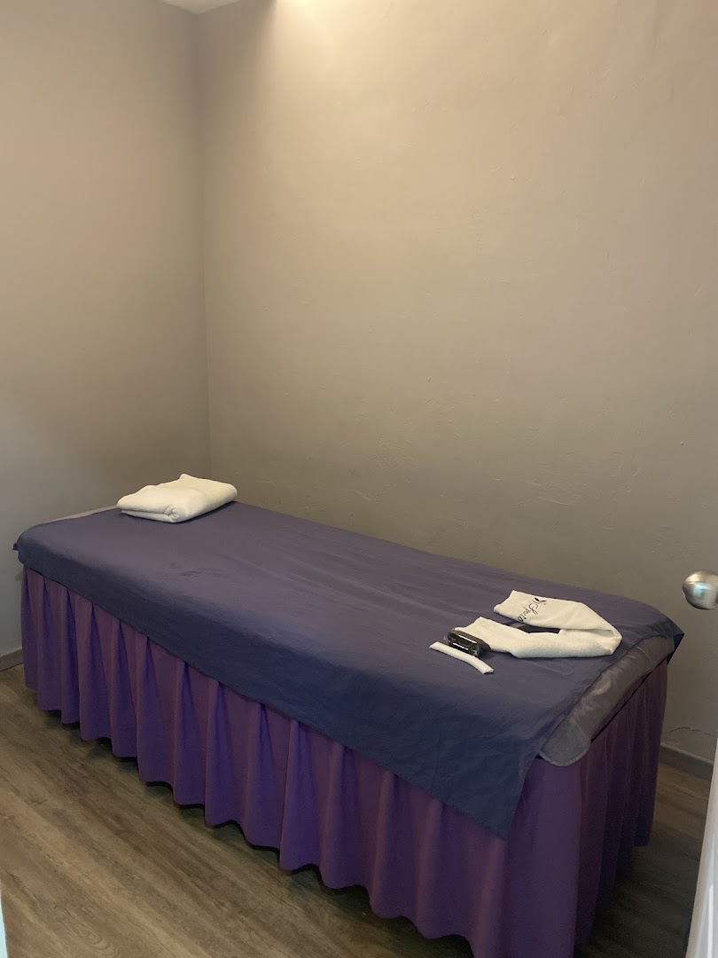An interior room with a massage bed and towels.