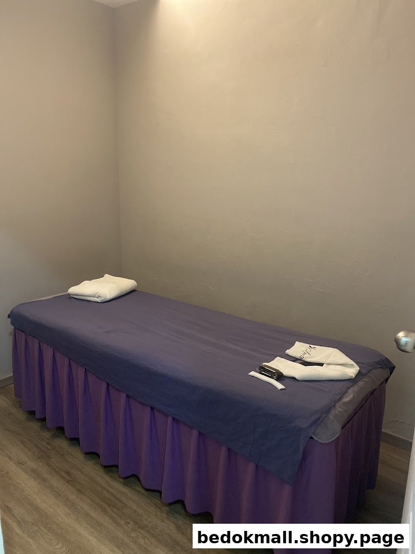 An interior room with a massage bed and towels.