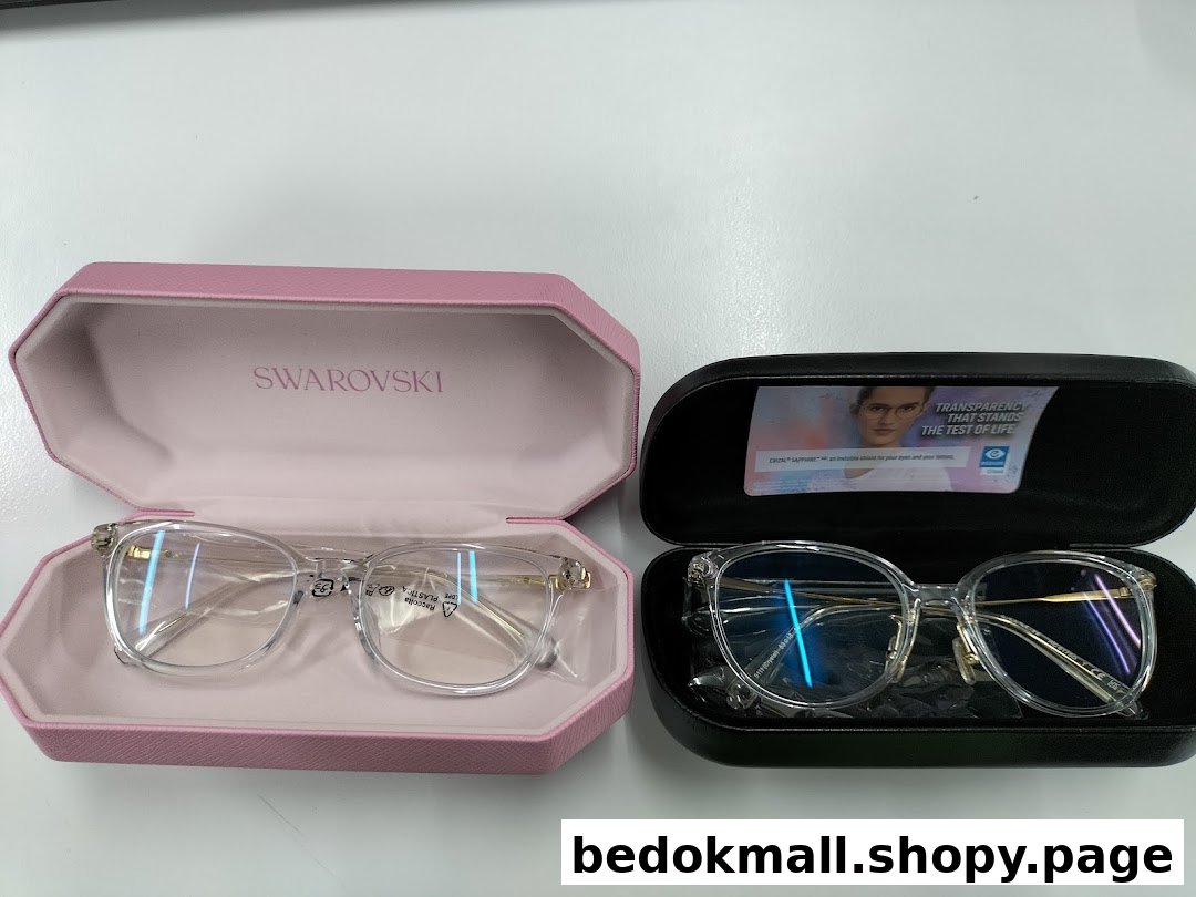 Two pairs of eyeglasses in open cases, one pink and one black.