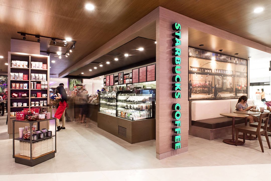 Starbucks interior with counter, merchandise shelves, and seating area.