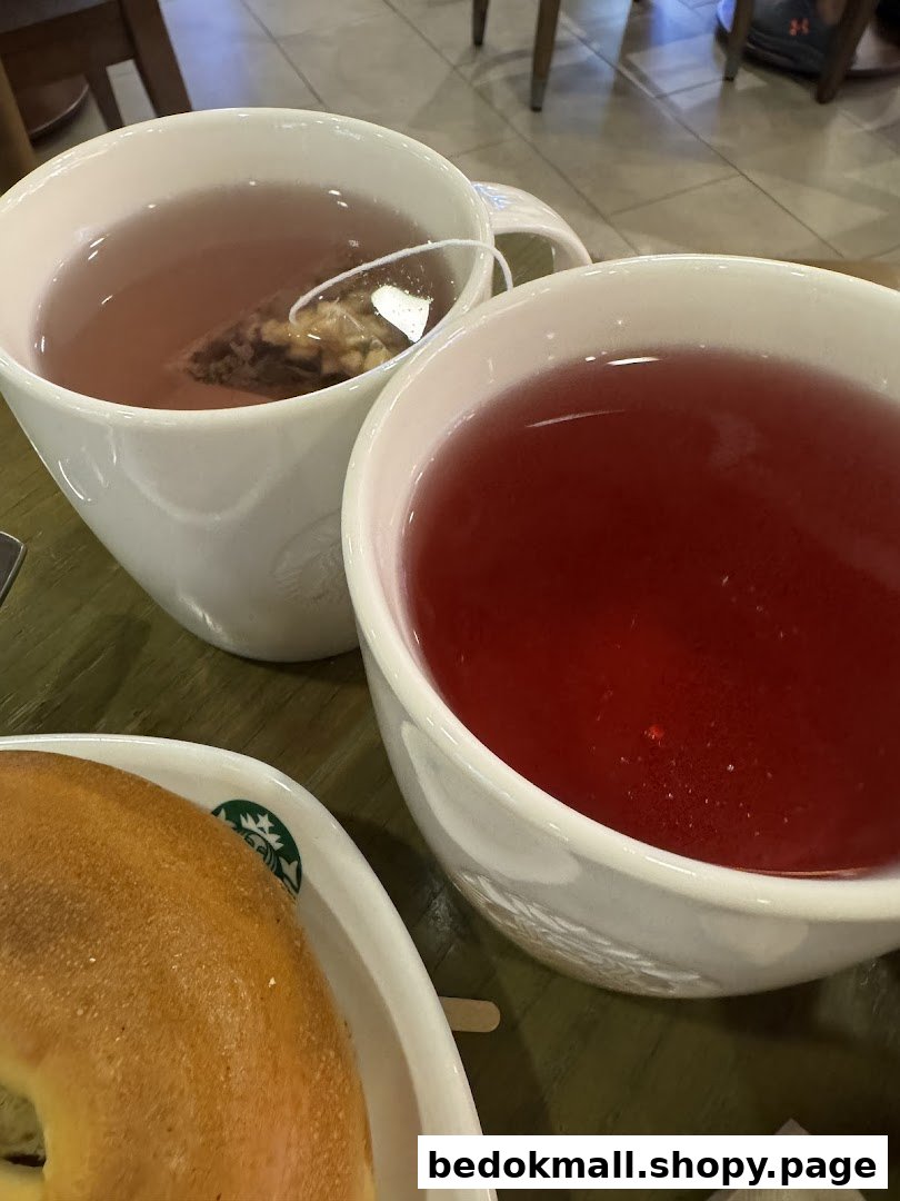 Two cups of tea and a bagel on a table at Starbucks.