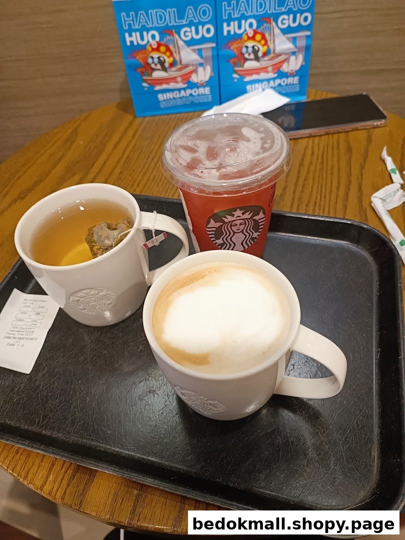 Three drinks on a tray on a wooden table with bags in the background.