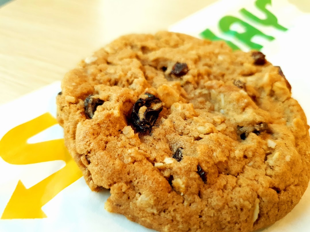 Close-up of a cookie with the Subway logo visible in the background.