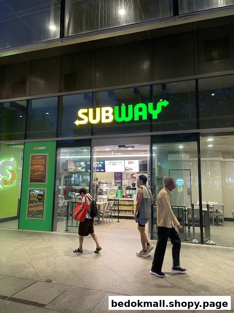 Subway shop exterior with people walking past.