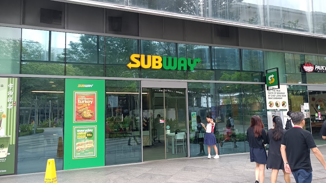 Exterior view of a Subway shop with its prominent sign and glass facade.