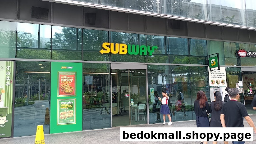 Exterior view of a Subway shop with its prominent sign and glass facade.