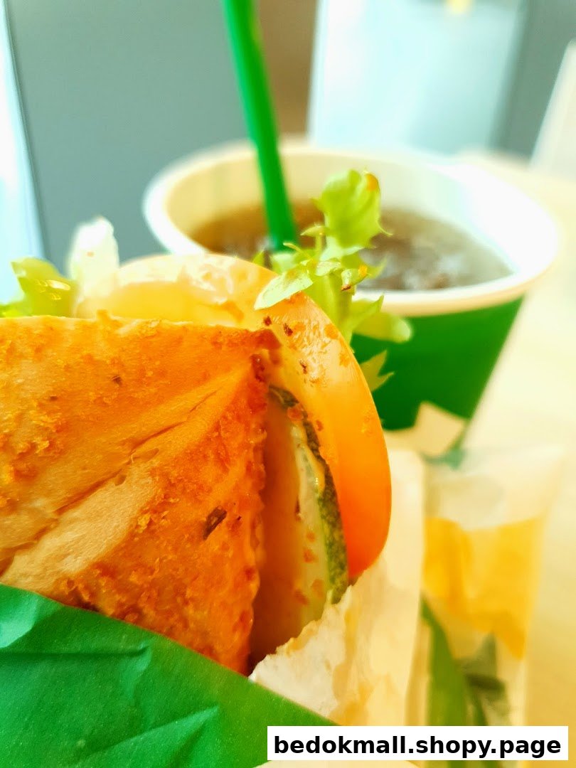 Close-up of a sandwich with vegetables and a drink in a cup.