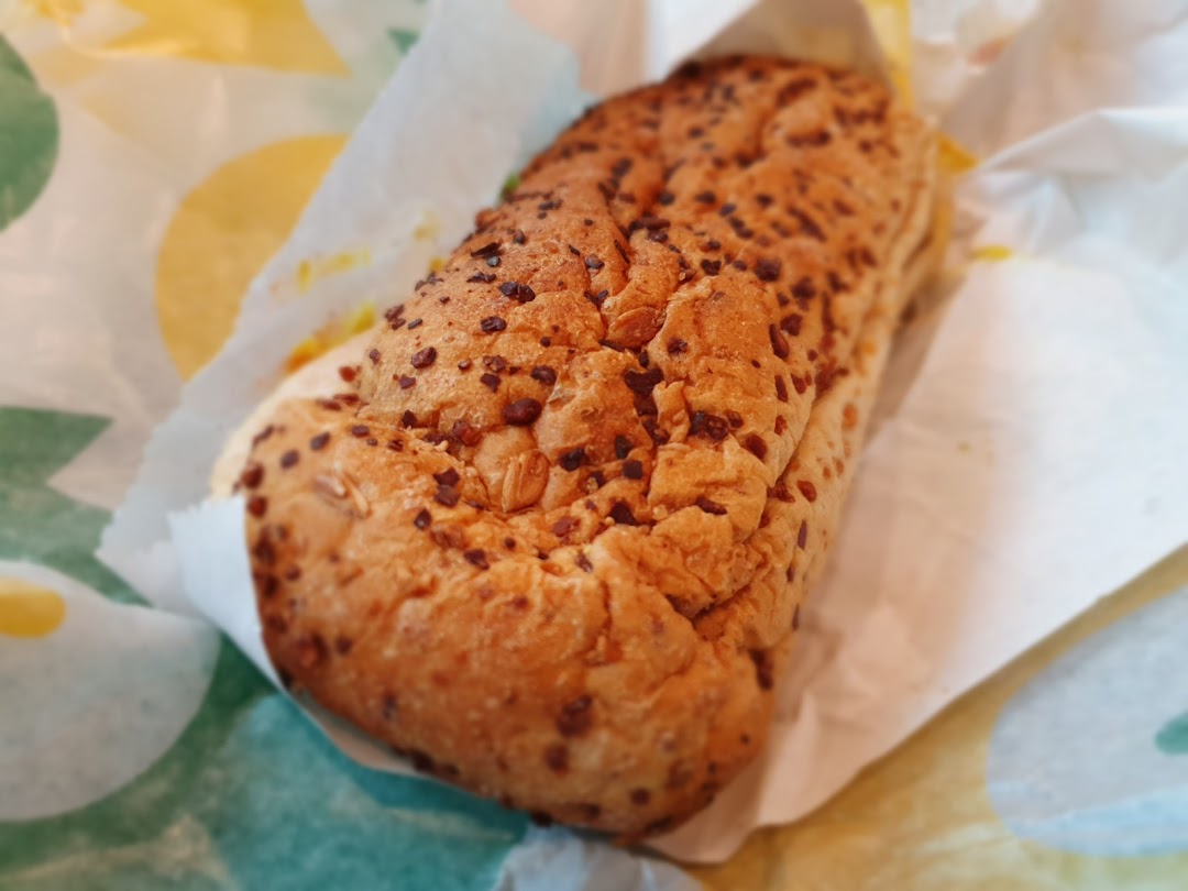 A Subway sandwich wrapped in branded paper.