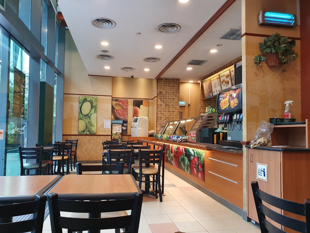 Interior view of a Subway restaurant with seating area and service counter.