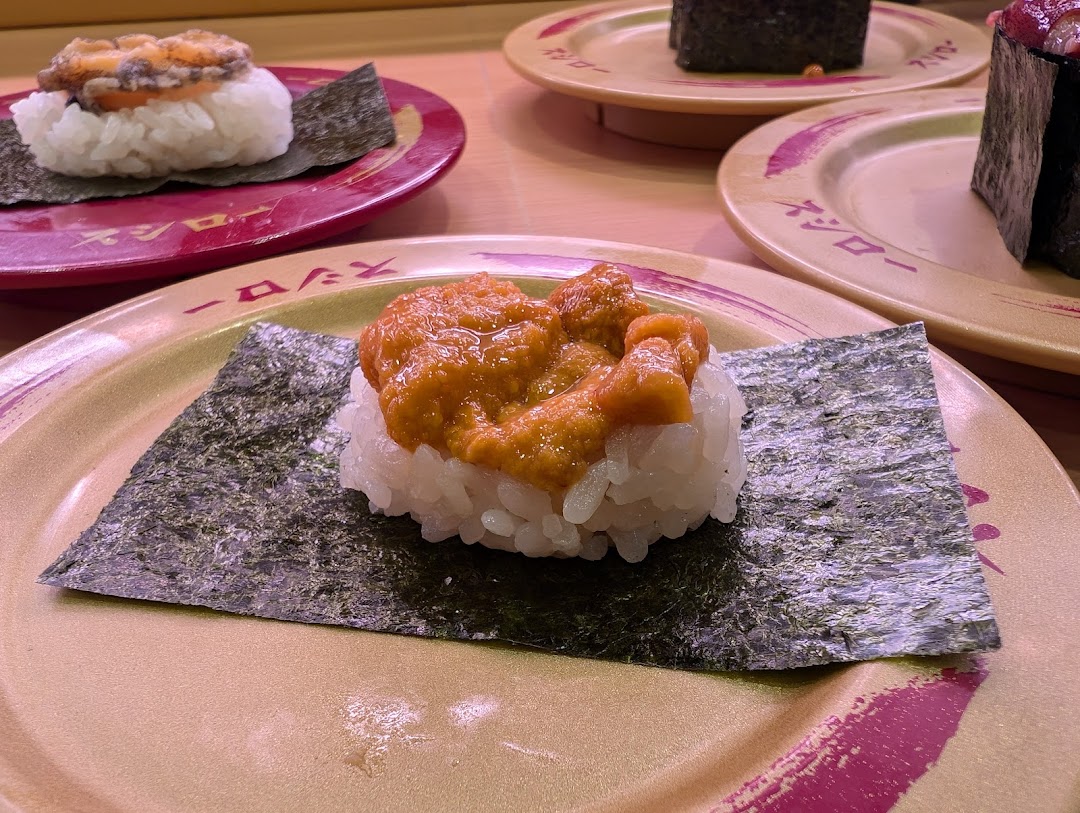 Close-up of various sushi dishes on plates at a restaurant.
