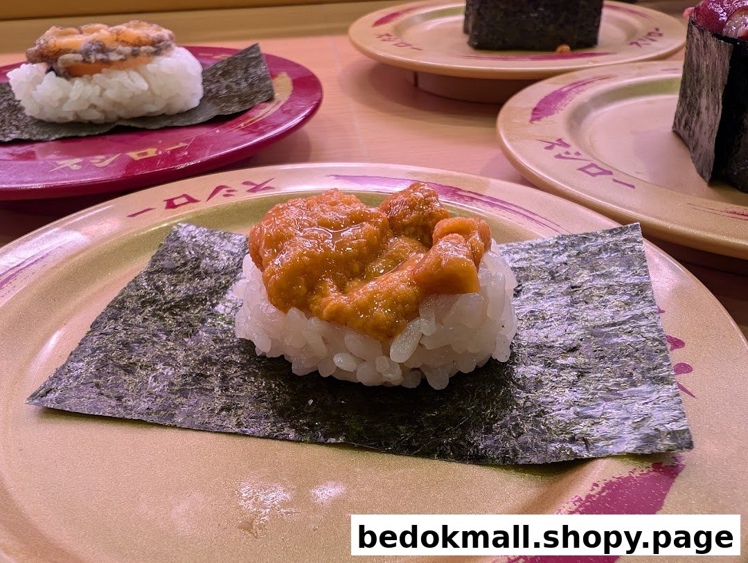 Close-up of various sushi dishes on plates at a restaurant.