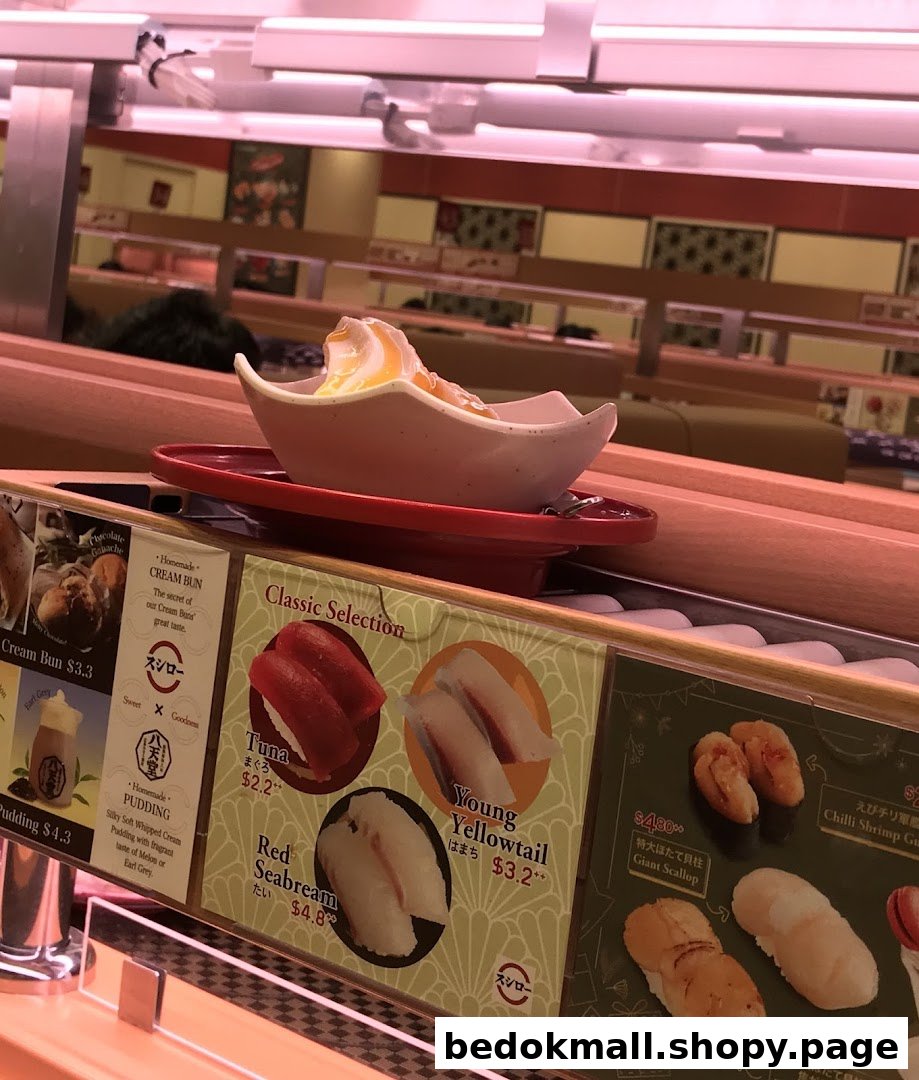 Conveyor belt sushi restaurant interior with food and menu displays.