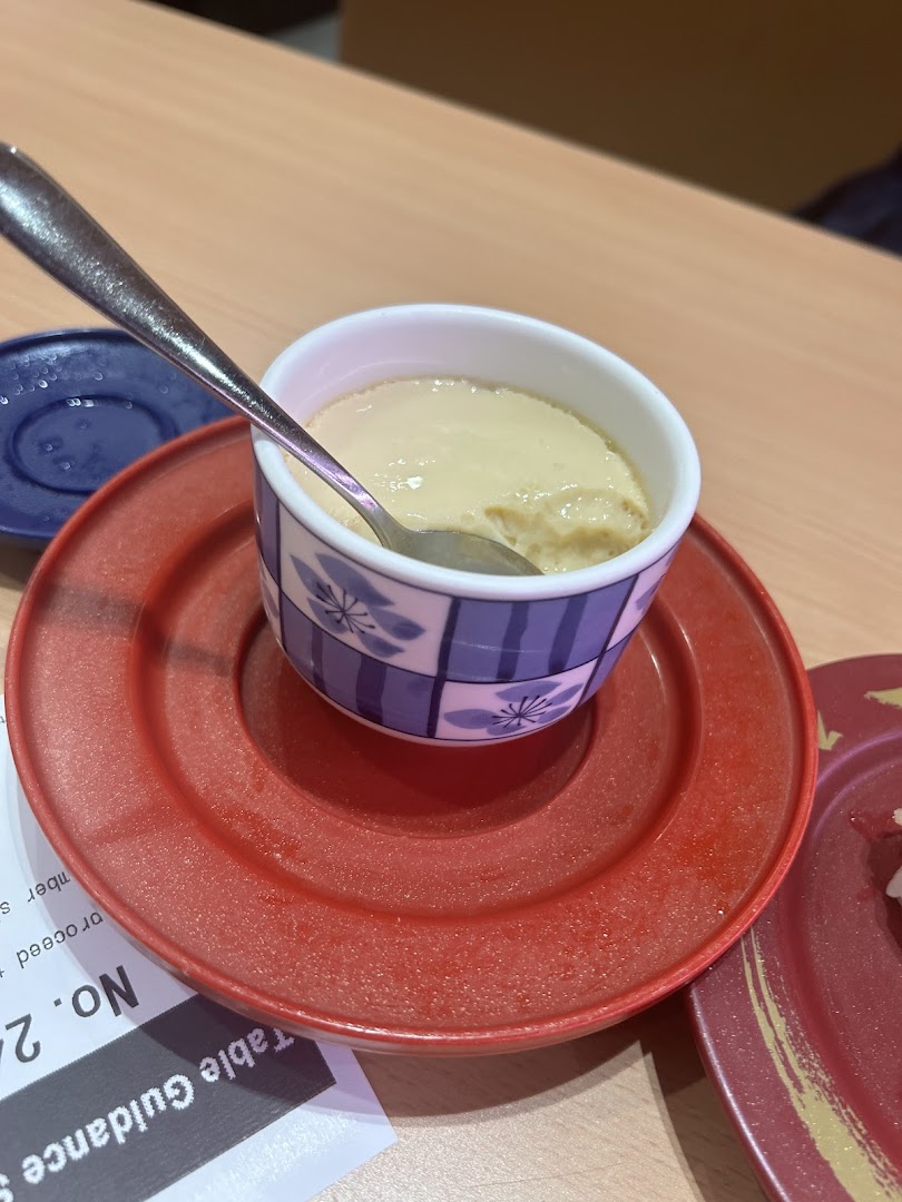 A close-up of a creamy dessert or custard in a bowl with a spoon.