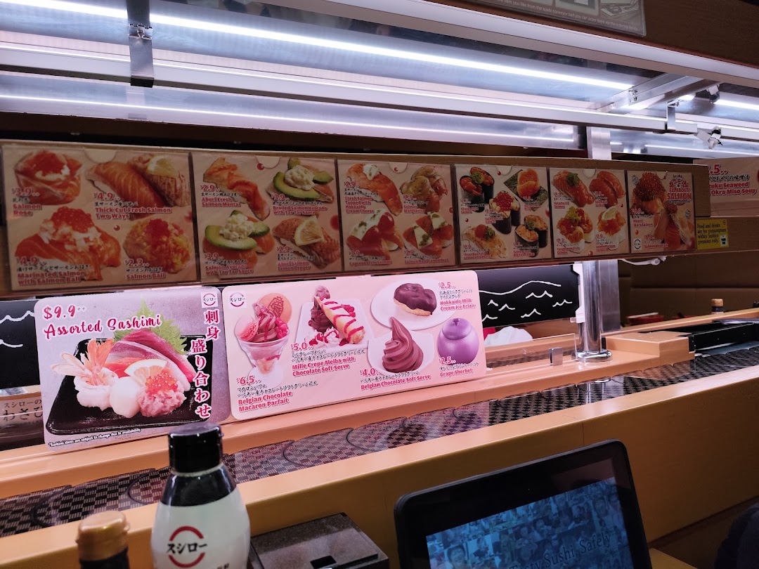 Conveyor belt sushi restaurant with various food menus displayed above the belt.