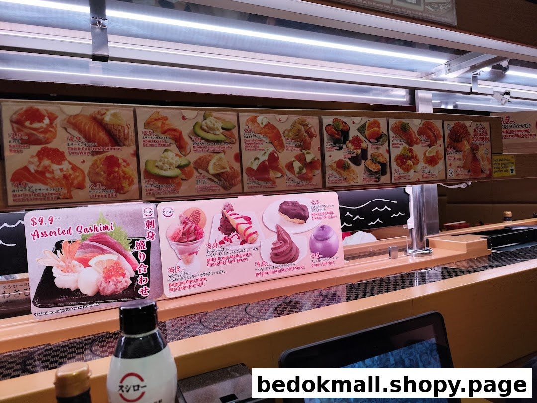 Conveyor belt sushi restaurant with various food menus displayed above the belt.