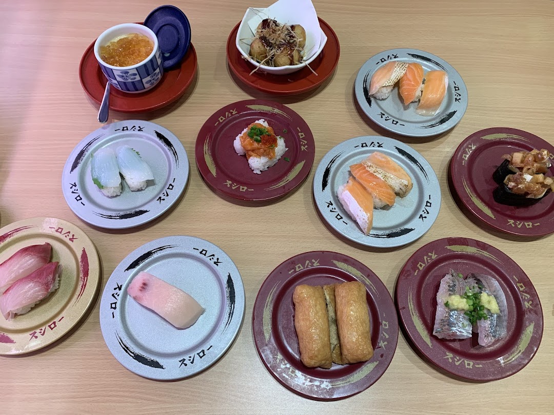 Various plates of sushi and Japanese dishes on a wooden table.