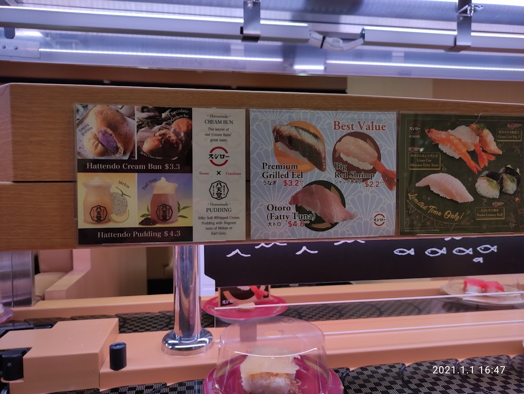 Food items and prices displayed above a sushi conveyor belt.