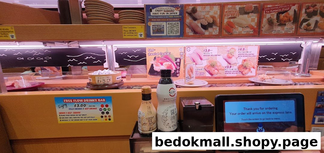 Interior view of a sushi restaurant with conveyor belt, ordering tablet, and condiments.